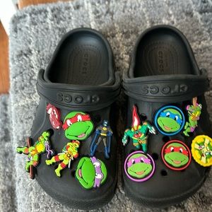 Black size 9 crocs covered with ninja turtles